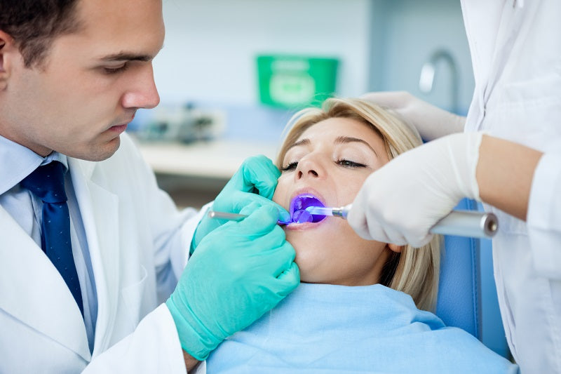 oral surgeon taking care of patient teeth