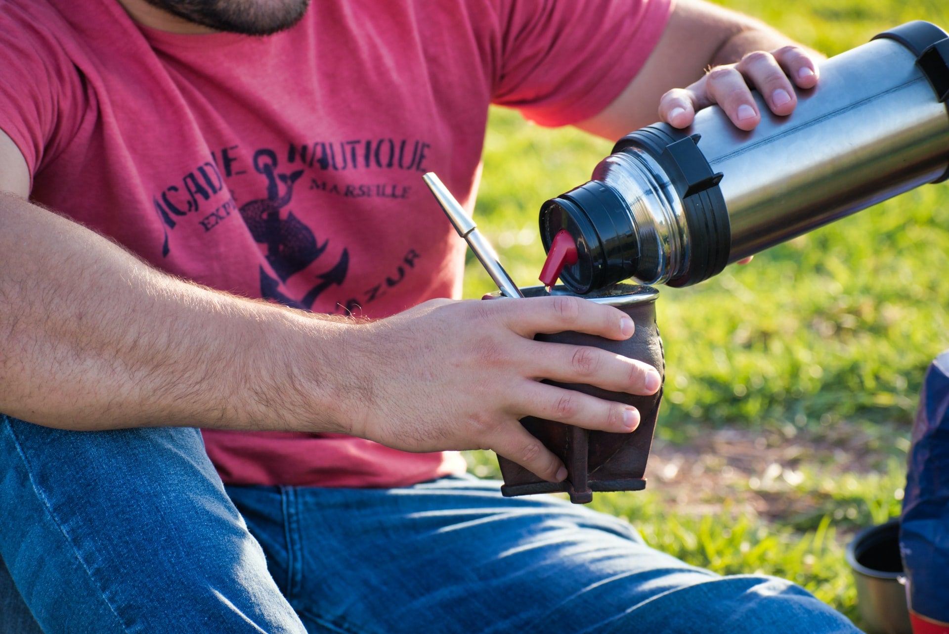 man pouring water from thermos