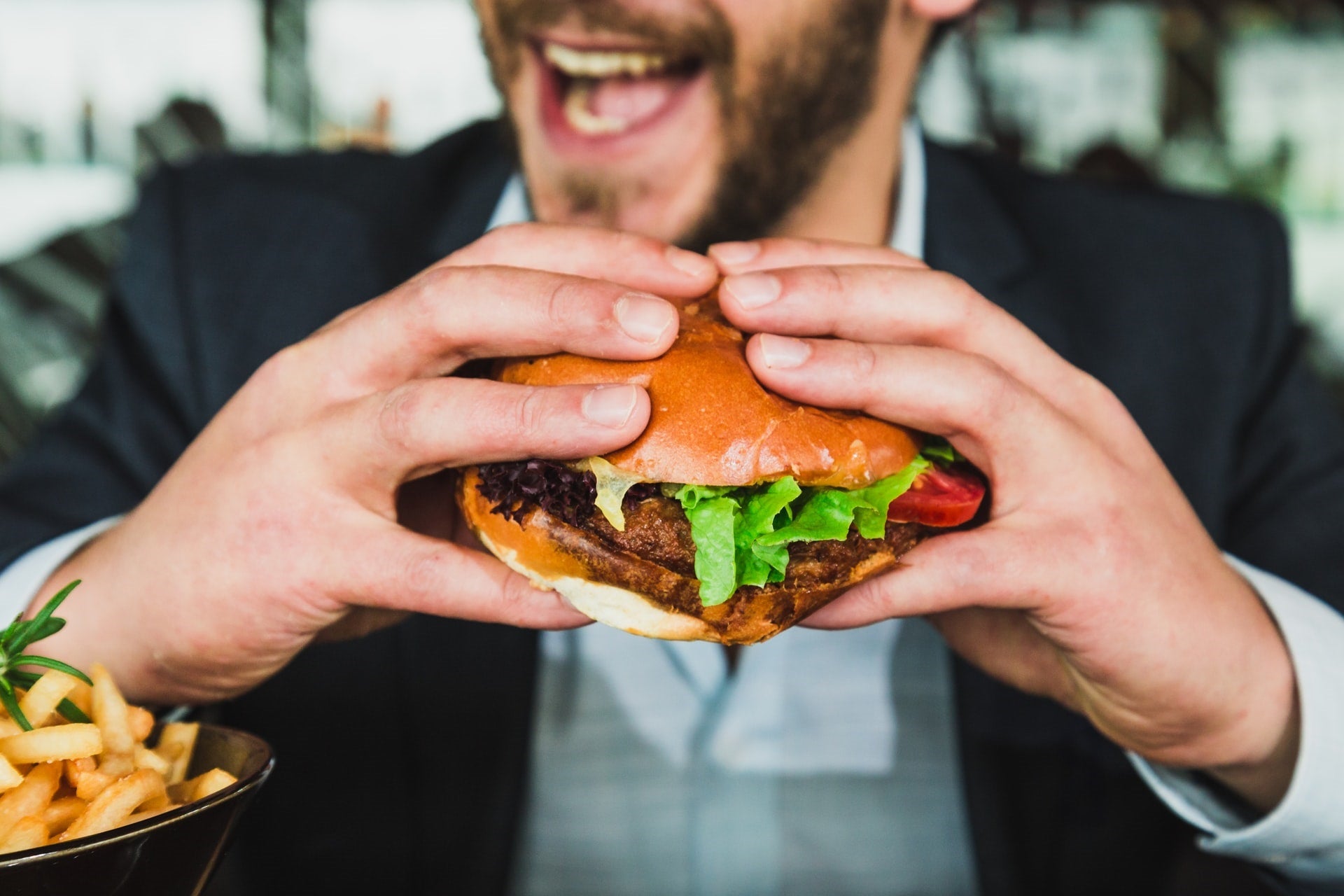 man eating hamburger processed fast food