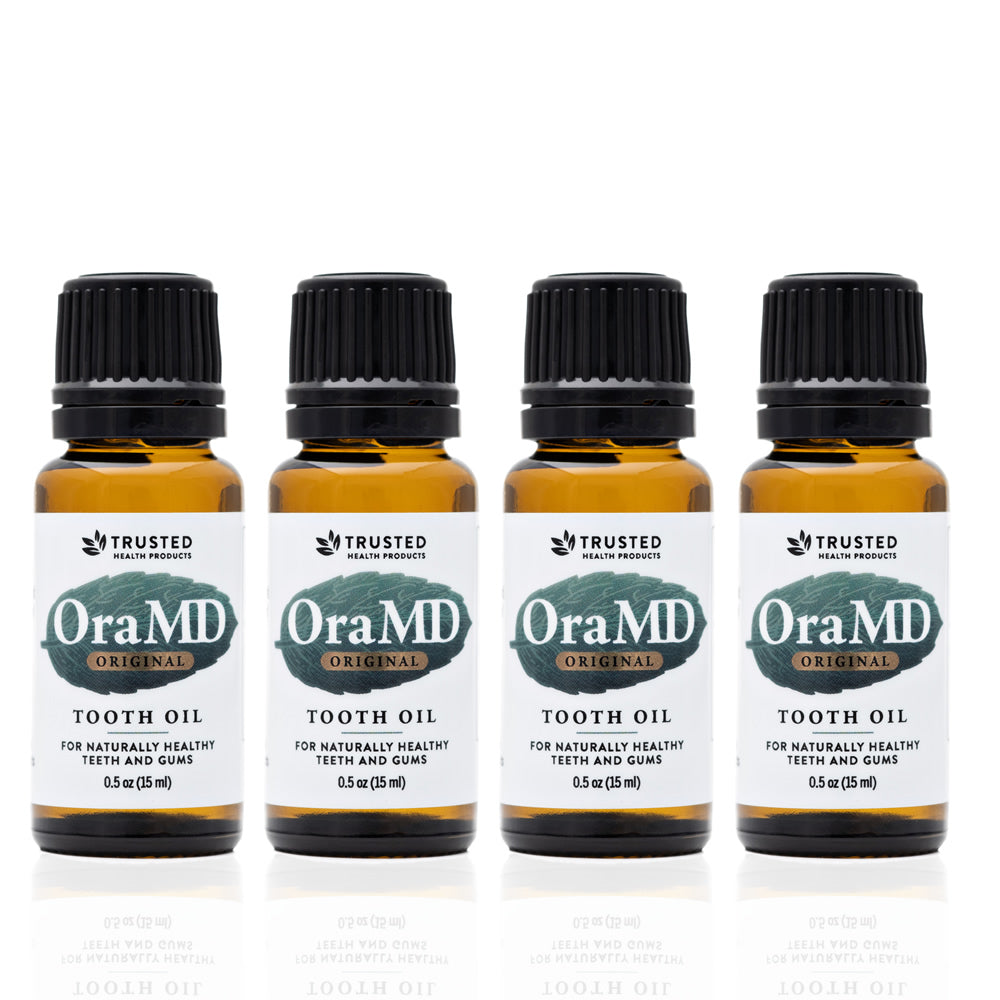 Four bottles of OraMD Extra Strength Tooth Oil on a white background