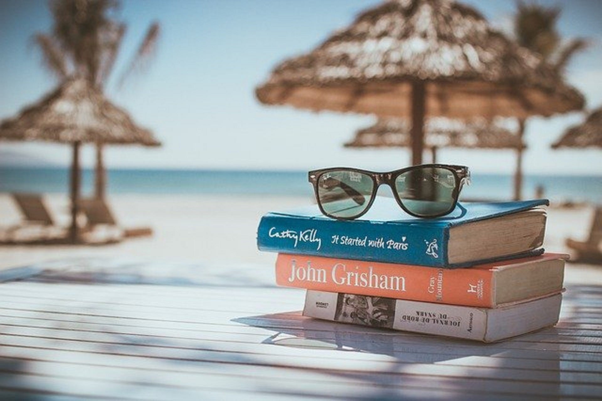 books and sunglasses on beach setting