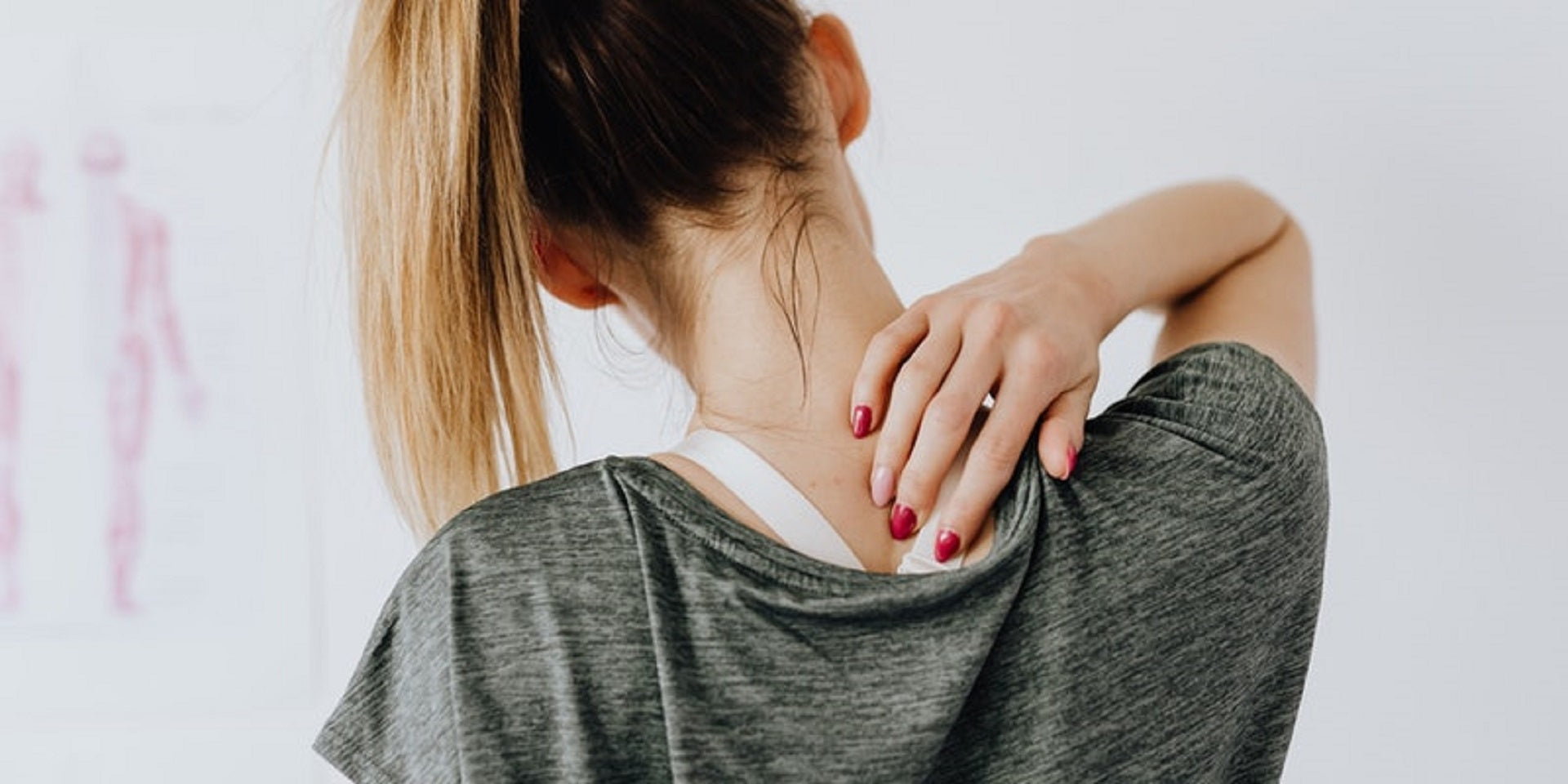 woman touching her upper back