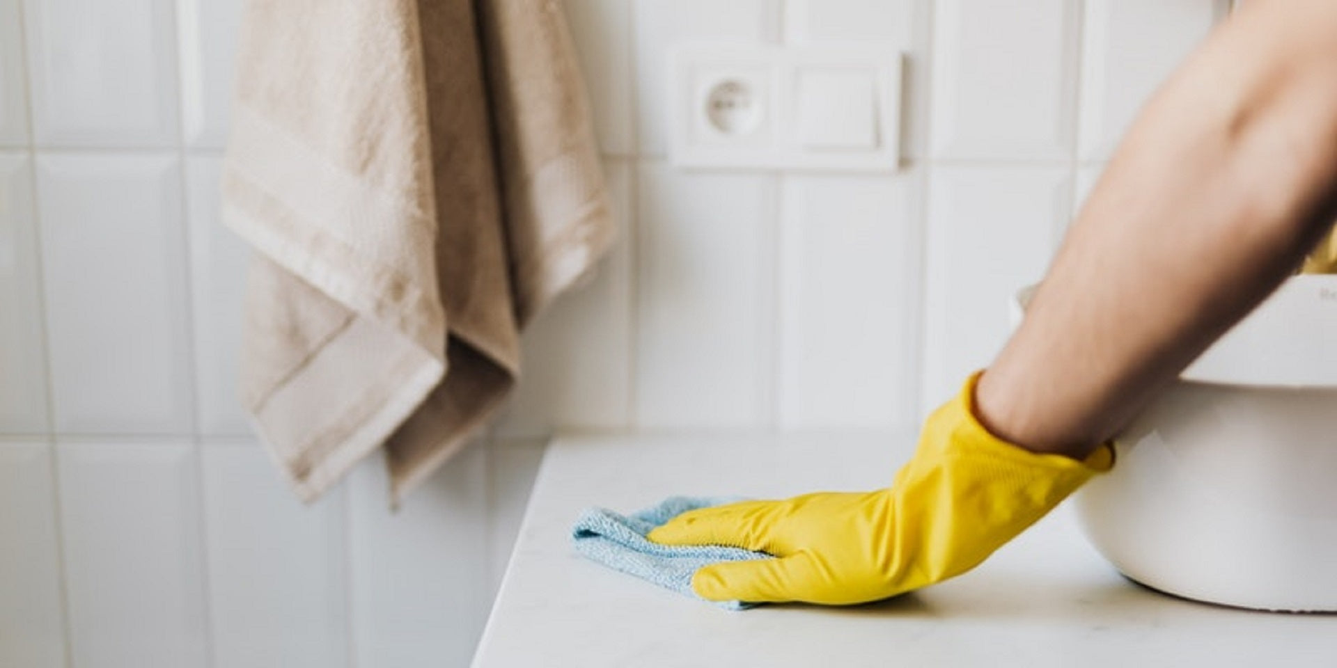 person wearing rubber glove cleaning counter