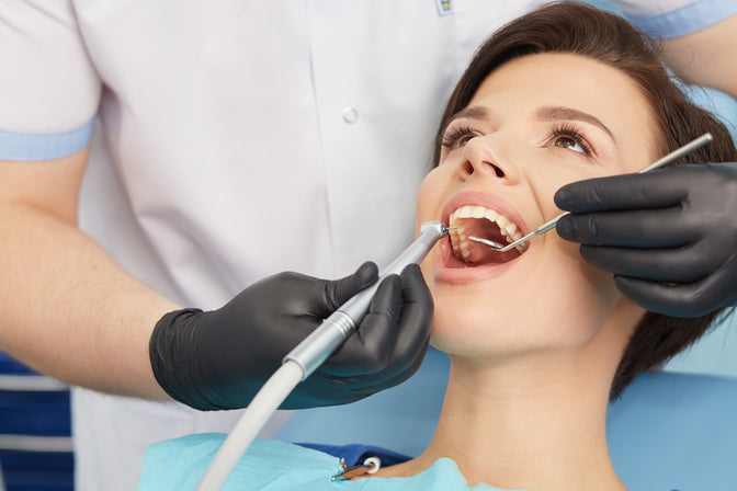 dentist cleaning patient's teeth