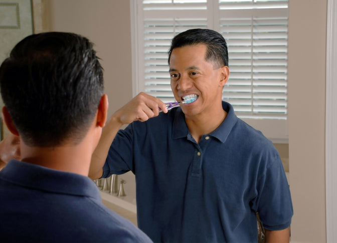 man brushing teeth to combat bad breath