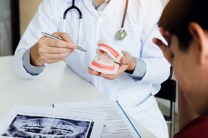 dentist showing patient set of dentures