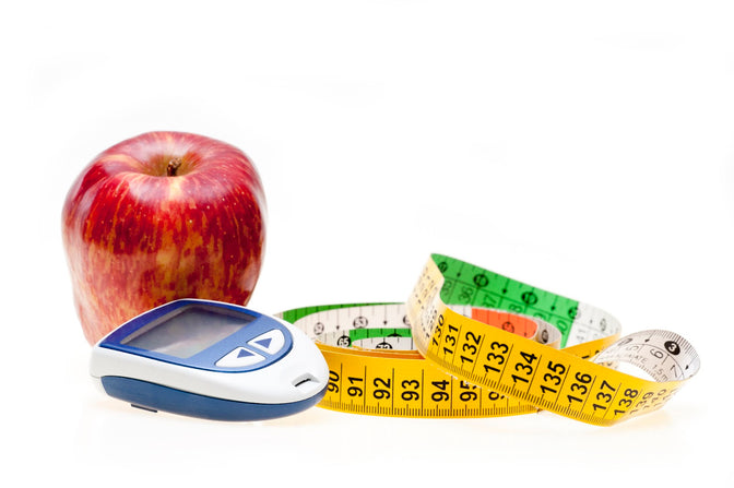 close up of a red apple, weighing scale and tape measure, natural starter pack for managing diabetes