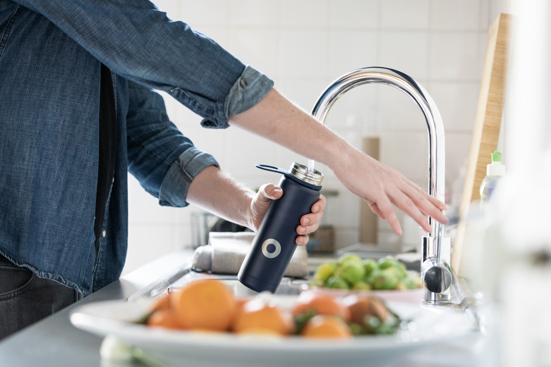 man filling water bottle