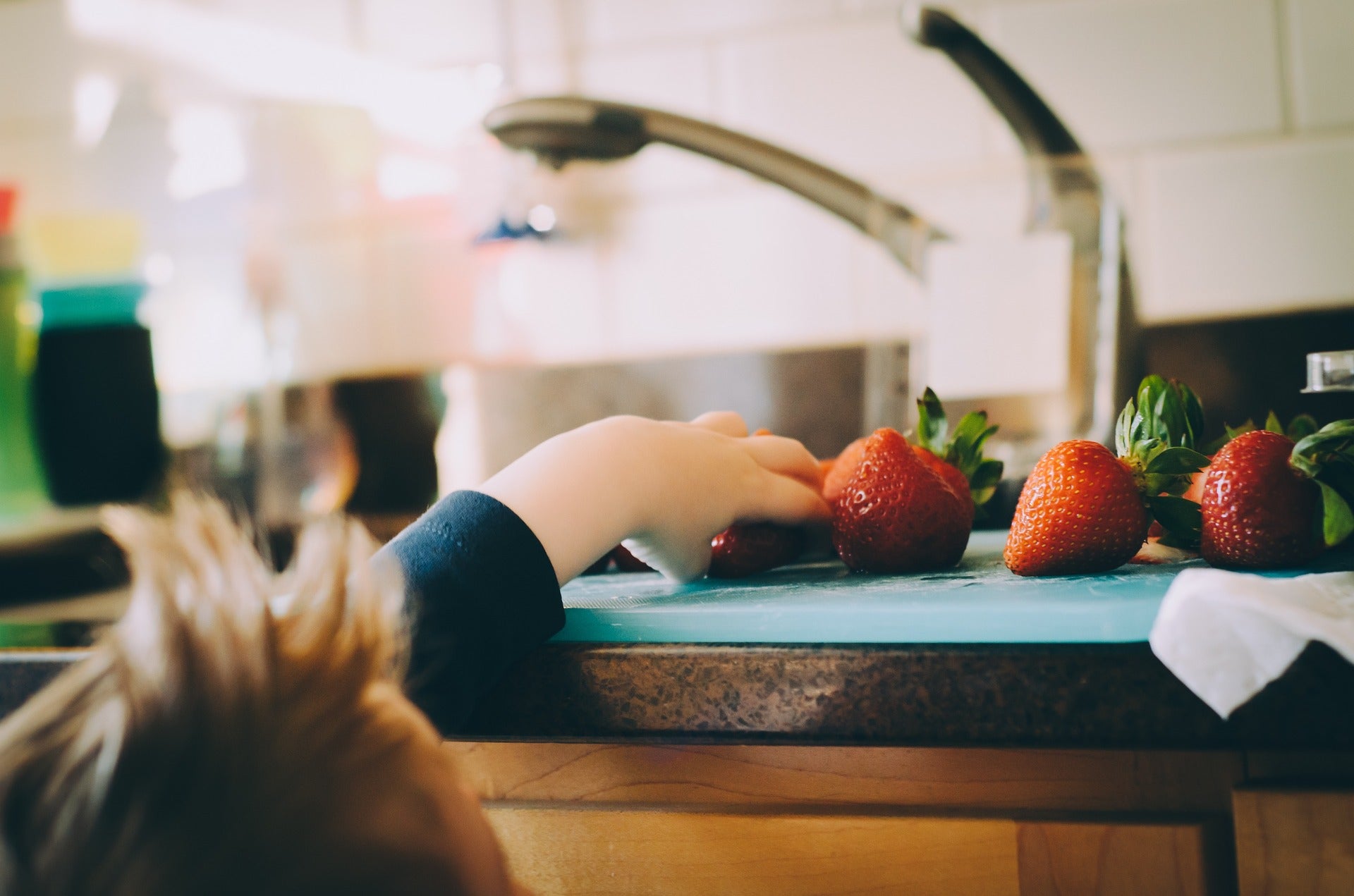 boy reaching for a strawberry