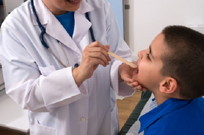 doctor checking boy for oral thrush