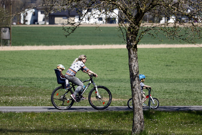 woman bicycling with children