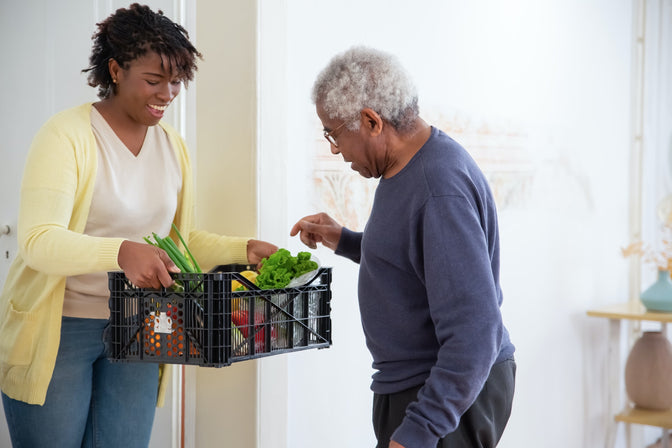 woman giving food to senior