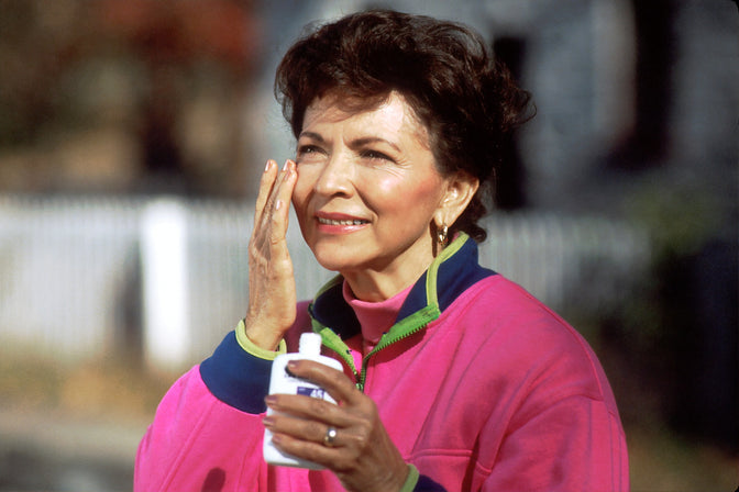 woman applying sunscreen on face