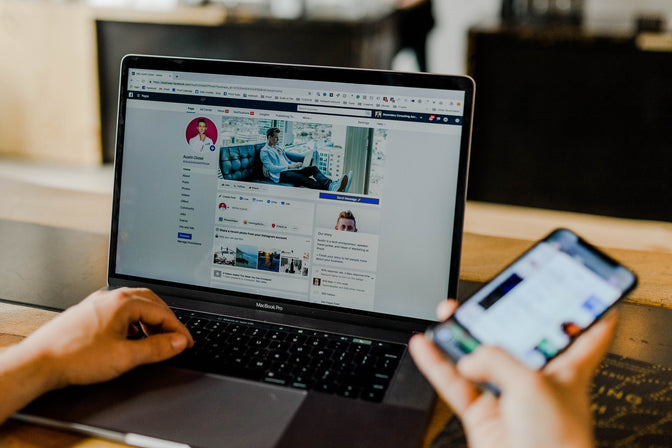 person looking at social media on computer and phone