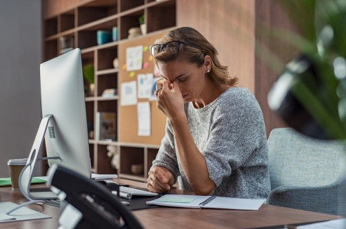 woman working at computer with stress