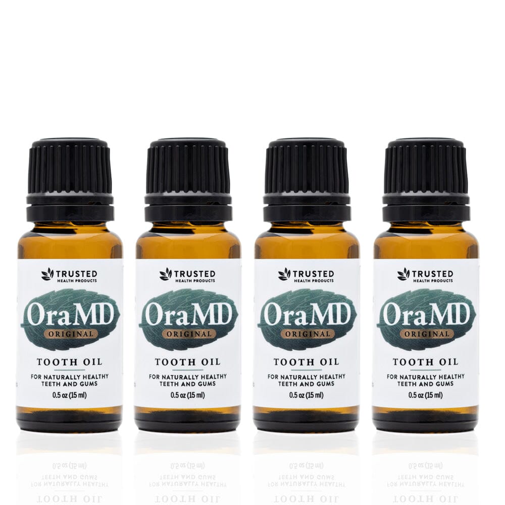 Four bottles of OraMD Extra Strength Tooth Oil on a white background